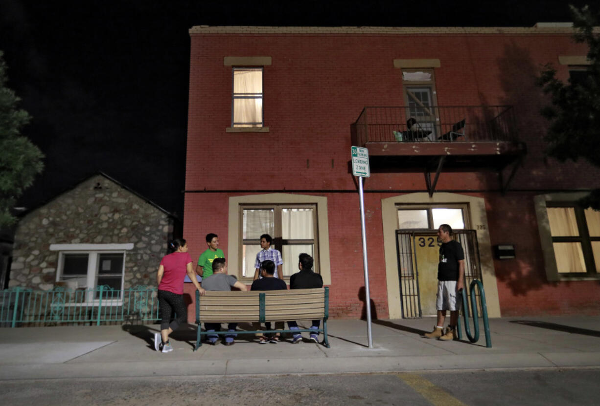 FILE - Migrant parents socialize outside the Annunciation House, June 26, 2018, in El Paso, Texas.  A Texas judge ruled against the state attorney general on Tuesday, July 2, 2024, in his effort to shut down a migrant shelter in El Paso that he claimed encourages illegal migration.