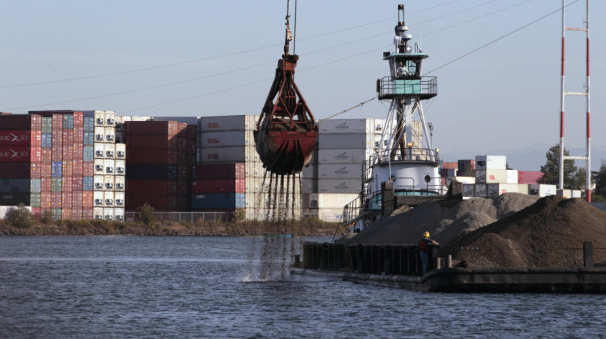 Shipping containers line one side of the Duwamish River and barges with gravel line another, Sept. 28, 2011, in Seattle. Ending an eight-year legal battle, chemical giant Monsanto has agreed to a $160-million settlement with Seattle for its part in polluting the Lower Duwamish River with toxins that posed a threat to humans and wildlife, the city attorney&rsquo;s office said in a press release Thursday, July 25, 2024.