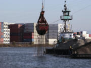 Shipping containers line one side of the Duwamish River and barges with gravel line another, Sept. 28, 2011, in Seattle. Ending an eight-year legal battle, chemical giant Monsanto has agreed to a $160-million settlement with Seattle for its part in polluting the Lower Duwamish River with toxins that posed a threat to humans and wildlife, the city attorney&rsquo;s office said in a press release Thursday, July 25, 2024.