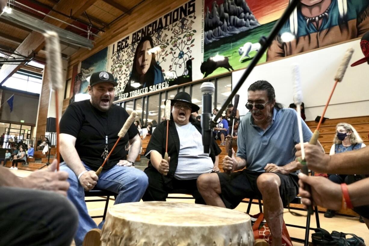 Mark Erickson, third from left, leads others in singing on the drum July 10 during an open drum and dance night at Minneapolis American Indian Center in Minneapolis, Minn.