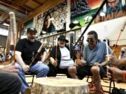 Mark Erickson, third from left, leads others in singing on the drum July 10 during an open drum and dance night at Minneapolis American Indian Center in Minneapolis, Minn.