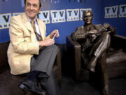 FILE - Actor-comedian Bob Newhart sits with a bronze likeness of Dr. Bob Hartley, the character he played in the 1972-78 sitcom &quot;The Bob Newhart Show,&quot; at the unveiling of the statue in Chicago on July 27, 2004. Newhart, the deadpan master of sitcoms and telephone monologues, died in Los Angeles on Thursday, July 18, 2024. He was 94. (AP Photo/M.
