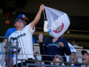 A fan holds up a hot dog attached to a parachute after catching it during a &ldquo;Hot Dogs from Heaven&rdquo; promotion after the bottom of the seventh inning of a baseball game between the Seattle Mariners and the Baltimore Orioles, Thursday, July 4, 2024, in Seattle.