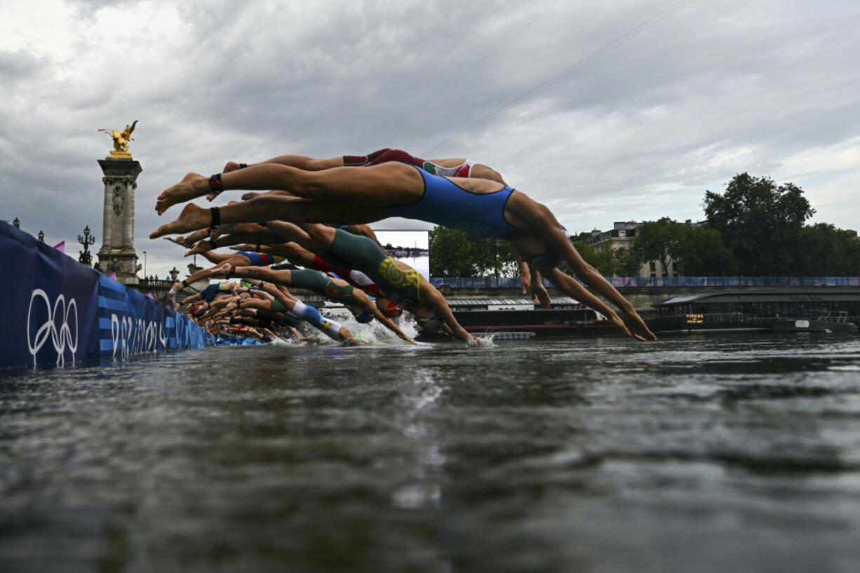 Athletes compete in the swimming race in the Seine during the women&#039;s individual triathlon at the 2024 Summer Olympics, Wednesday, July 31, 2024 in Paris, France.