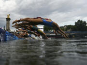 Athletes compete in the swimming race in the Seine during the women&#039;s individual triathlon at the 2024 Summer Olympics, Wednesday, July 31, 2024 in Paris, France.