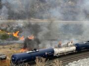 Workers on a Union Pacific water train spray water to aid in firefighting along the Interstate 84 corridor in Oregon on Wednesday.