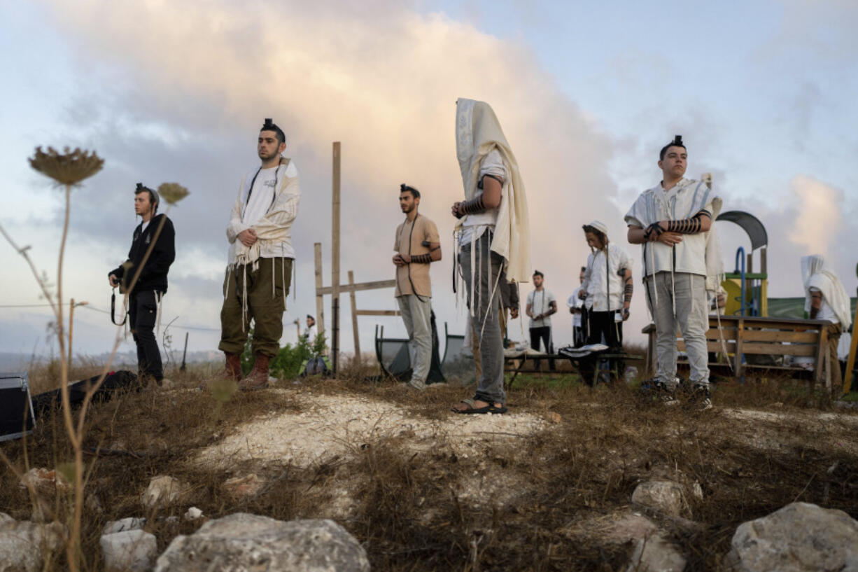 Jewish settlers pray in the Eviatar outpost in the Israeli-occupied West Bank during morning prayers calling for the legalization of the outpost and the return of the hostages held in the Gaza Strip by the Hamas militant group, July 7, 2024.