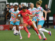 Portland forward Sophia Smith, center, weaves between defenders Friday, July 5, 2024, during the Thorns’ 1-0 win against San Diego Wave FC at Providence Park in Portland.