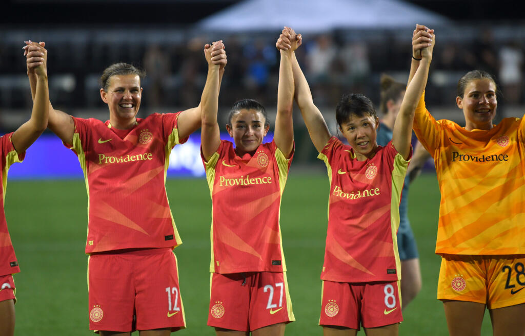 Portland forward Christine Sinclair, from left, midfielder Marissa Sheva, midfielder Hina Sugita and goalkeeper Lauren Kozal raise their arms Friday, July 5, 2024, after the Thorns’ 1-0 win against San Diego Wave FC at Providence Park in Portland.