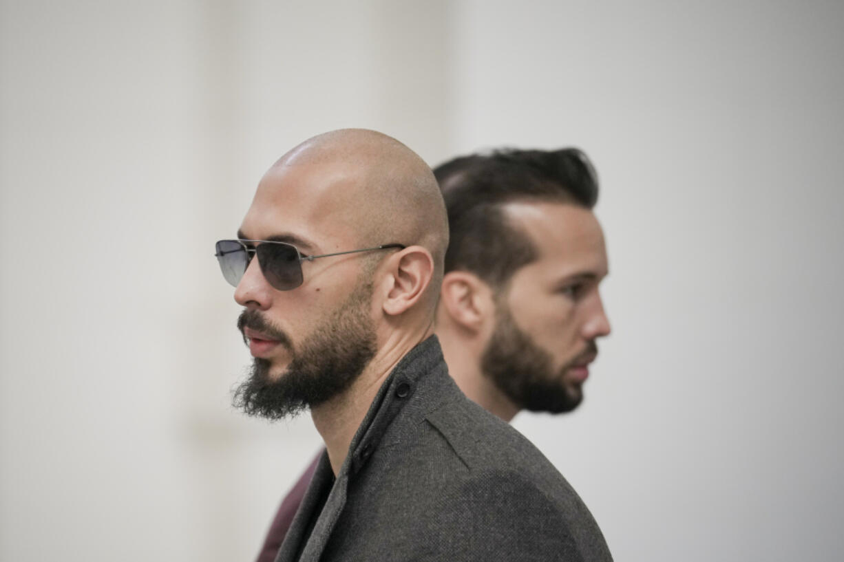 FILE - Andrew Tate, left, and his brother Tristan, right, wait inside the Court of Appeals building in Bucharest, Romania, Tuesday, Jan. 30, 2024. A court in Romania&rsquo;s capital on Friday, July 5, 2024 ruled that the online influencer Andrew Tate can leave Romanian territory providing he remains within the European Union, as he awaits trial on charges of human trafficking, rape and forming a criminal gang to sexually exploit women.