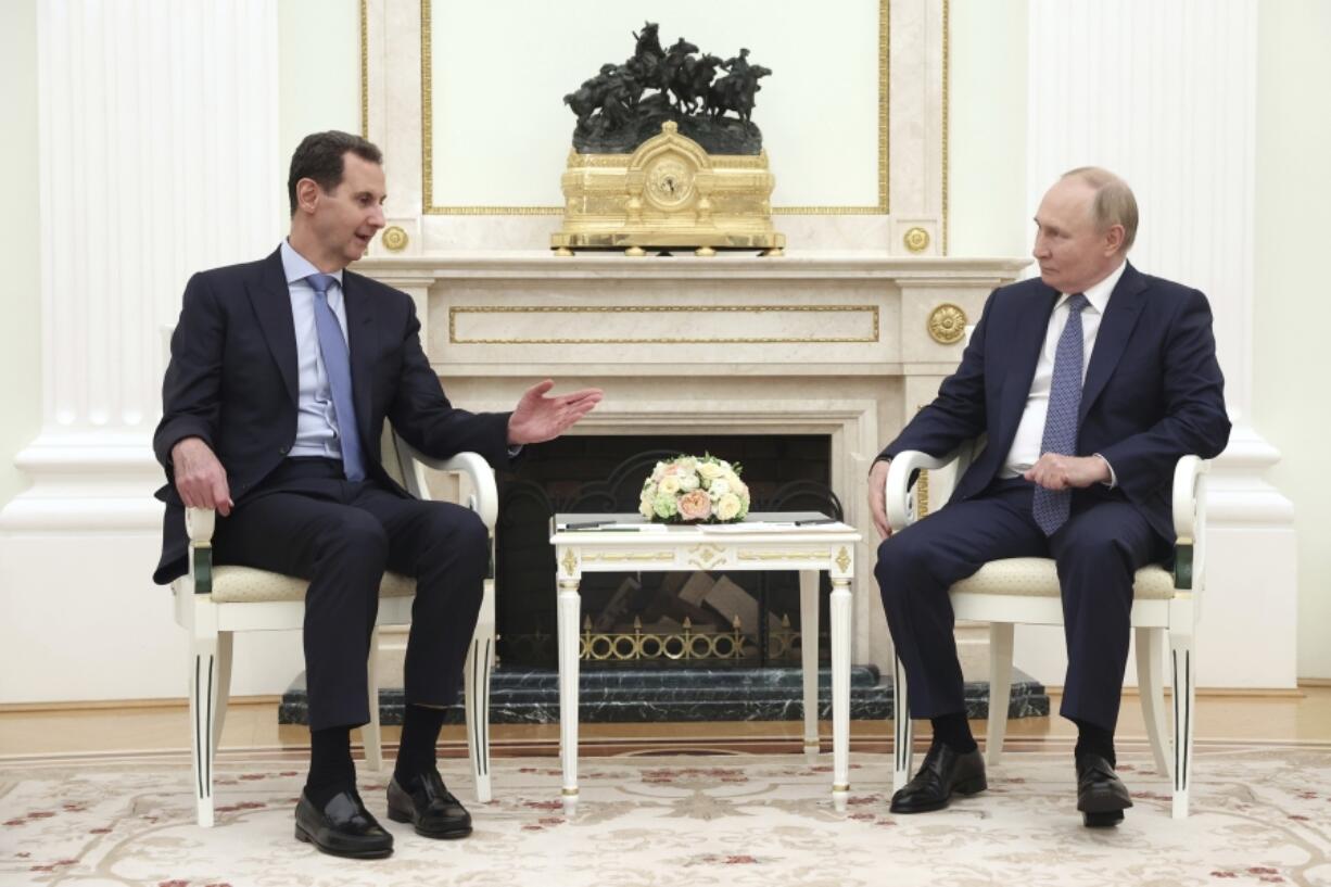 Syrian President Bashar Assad, left, speaks with Russian President Vladimir Putin during their meeting in Moscow, Russia, Wednesday, July 24, 2024.