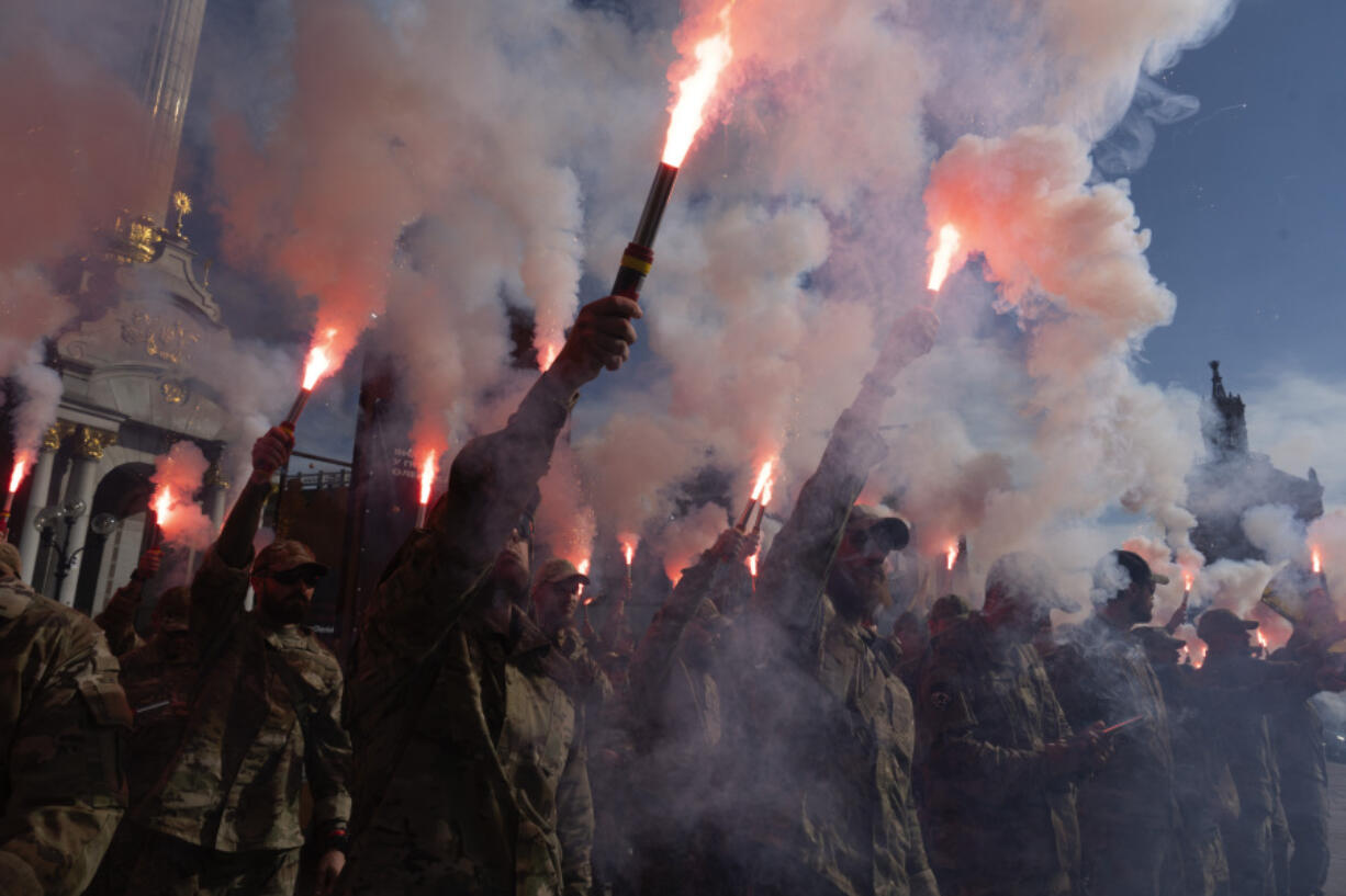 Soldiers of Ukraine&#039;s Azov battalion light flares at a rally demanding to free Ukrainian prisoners of war who are held in captivity in Russia at Independence Square in Kyiv, Ukraine, Sunday, July 28, 2024. Several thousand people and soldiers gathered to commemorate the second anniversary of a Russia-orchestrated explosion that killed more than 50 Ukrainian prisoners of war in the Russian-held Olenivka prison barracks.