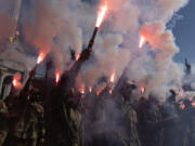 Soldiers of Ukraine&#039;s Azov battalion light flares at a rally demanding to free Ukrainian prisoners of war who are held in captivity in Russia at Independence Square in Kyiv, Ukraine, Sunday, July 28, 2024. Several thousand people and soldiers gathered to commemorate the second anniversary of a Russia-orchestrated explosion that killed more than 50 Ukrainian prisoners of war in the Russian-held Olenivka prison barracks.