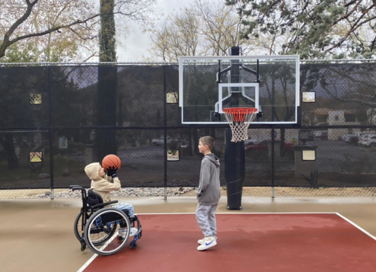 This undated photo provided by Jasculca Terman Strategic Communications shows twin brothers Cooper and Luke Roberts playing basketball. Cooper was a victim of the 2022 Fourth of July parade shooting in Highland Park, Ill., and remains paralyzed from the waist down. Keely Roberts, the mother of the youngest victims of the Fourth of July parade shooting, which left one of her twin sons &mdash; now 10 &mdash; paralyzed from the waist down, will talk to the media Wednesday, July 3, 2024, about what it means to survive the horror two years later.