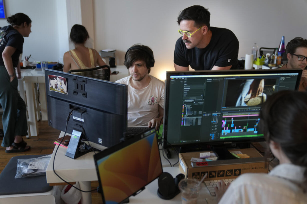 Chris Langer, top right, co-founder of CMYK, a digital design agency, speaks with a staff member June 25 at their office in New York. Last year, Langer started hearing chatter about the four-day work week, so he decided to try it out during the summer.