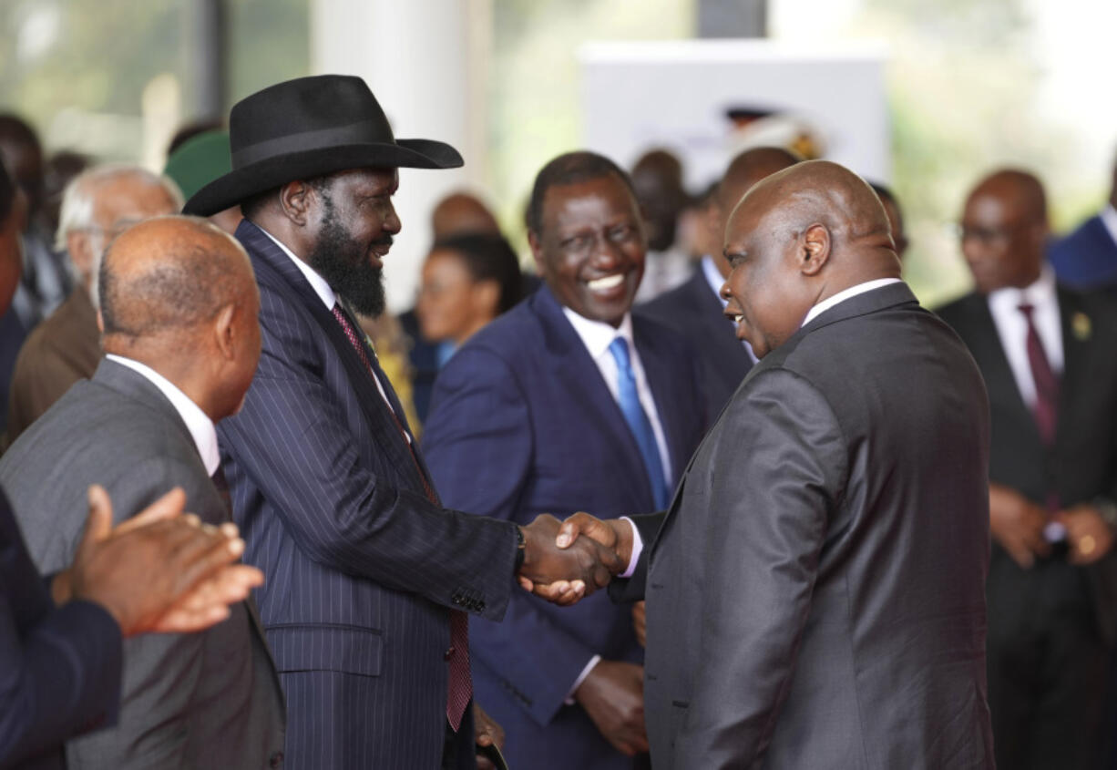 FILE - South Sudanese President Salva Kiir Mayardit, left, shakes hands with Pagan Amum Okiech, leader of the Real-SPLM group, during the launch of high-level peace talks for South Sudan at State House in Nairobi, Kenya, on Thursday, May 9, 2024.  South Sudan peace talks that almost reached completion faced a stumbling block with opposition groups demanding a newly passed bill allowing the detention of people without an arrest warrant scratched out in order to sign a proposed agreement.