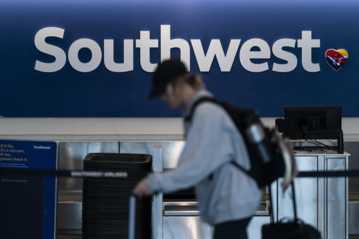 FILE - A traveler walks through the Southwest Airlines ticketing counter area at the Los Angeles International Airport in Los Angeles, April 18, 2023. Federal officials are investigating an incident on July 14, 2024, in which a Southwest jet flew as low as 150 feet (45 meters) over water while it was still several miles from its intended landing spot at the airport in Tampa, Fla. (AP Photo/Jae C.