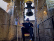 Sitting in a chair with ropes looped around both feet and hands, Joan Carles Osuna, a student of the Vall d&rsquo;en Bas School of Bell Ringers, performs June 29 playing all four bronze bells at the church bell tower of the12th-century Sant Rom&agrave; church, at the village of Joanetes, about two hours north of Barcelona, Spain.