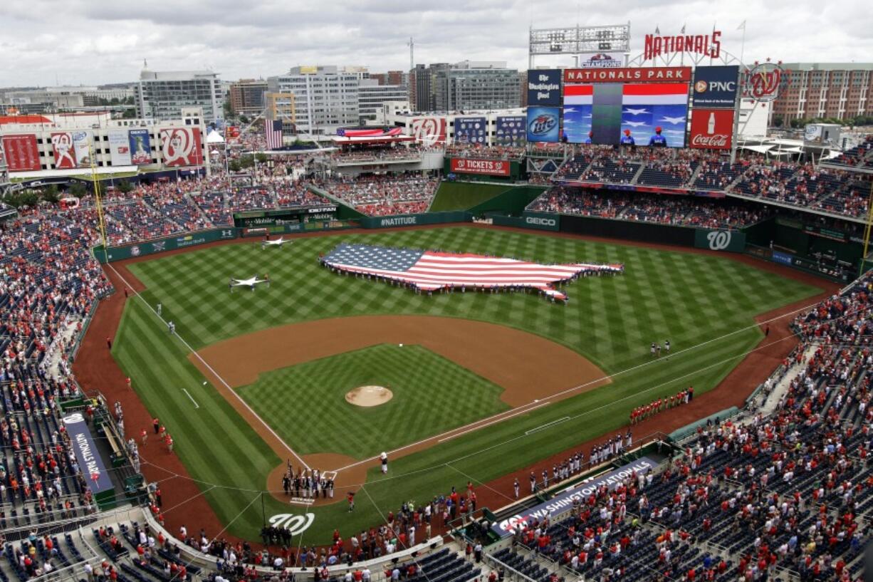 FILE - This July 4, 2013, file photo shows a U.S. flag, in the shape of the country, in the outfield before a baseball game between the Washington Nationals and the Milwaukee Brewers at Nationals Park in Washington. The attorney general for Washington, D.C. has sued StubHub, accusing the ticket resale platform of advertising deceptively low prices and then ramping up prices with extra fees. Attorney General Brian Schwalb said Wednesday the practice known as drip pricing violates consumer protection laws in the nation&rsquo;s capital. The lawsuit says StubHub has sold nearly 5 million tickets in Washington since implementing the practice in 2015 and reaped about $118 million in fees.