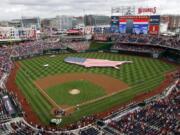 FILE - This July 4, 2013, file photo shows a U.S. flag, in the shape of the country, in the outfield before a baseball game between the Washington Nationals and the Milwaukee Brewers at Nationals Park in Washington. The attorney general for Washington, D.C. has sued StubHub, accusing the ticket resale platform of advertising deceptively low prices and then ramping up prices with extra fees. Attorney General Brian Schwalb said Wednesday the practice known as drip pricing violates consumer protection laws in the nation&rsquo;s capital. The lawsuit says StubHub has sold nearly 5 million tickets in Washington since implementing the practice in 2015 and reaped about $118 million in fees.