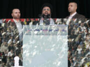 FILE - Hezbollah leader Sayyed Hassan Nasrallah, center, escorted by his bodyguard Yasser Nemr Qranbish, right, addresses supporters reflected in the bulletproof glass during the annual rally to mark Al-Quds Day, Jerusalem Day, in the southern suburbs of Beirut, Lebanon, on Oct. 28, 2005. An Israeli strike in Syria Tuesday July 9, 2024 killed Qranbish, a former personal bodyguard of Hezbollah leader, an official with the Lebanese militant group said.