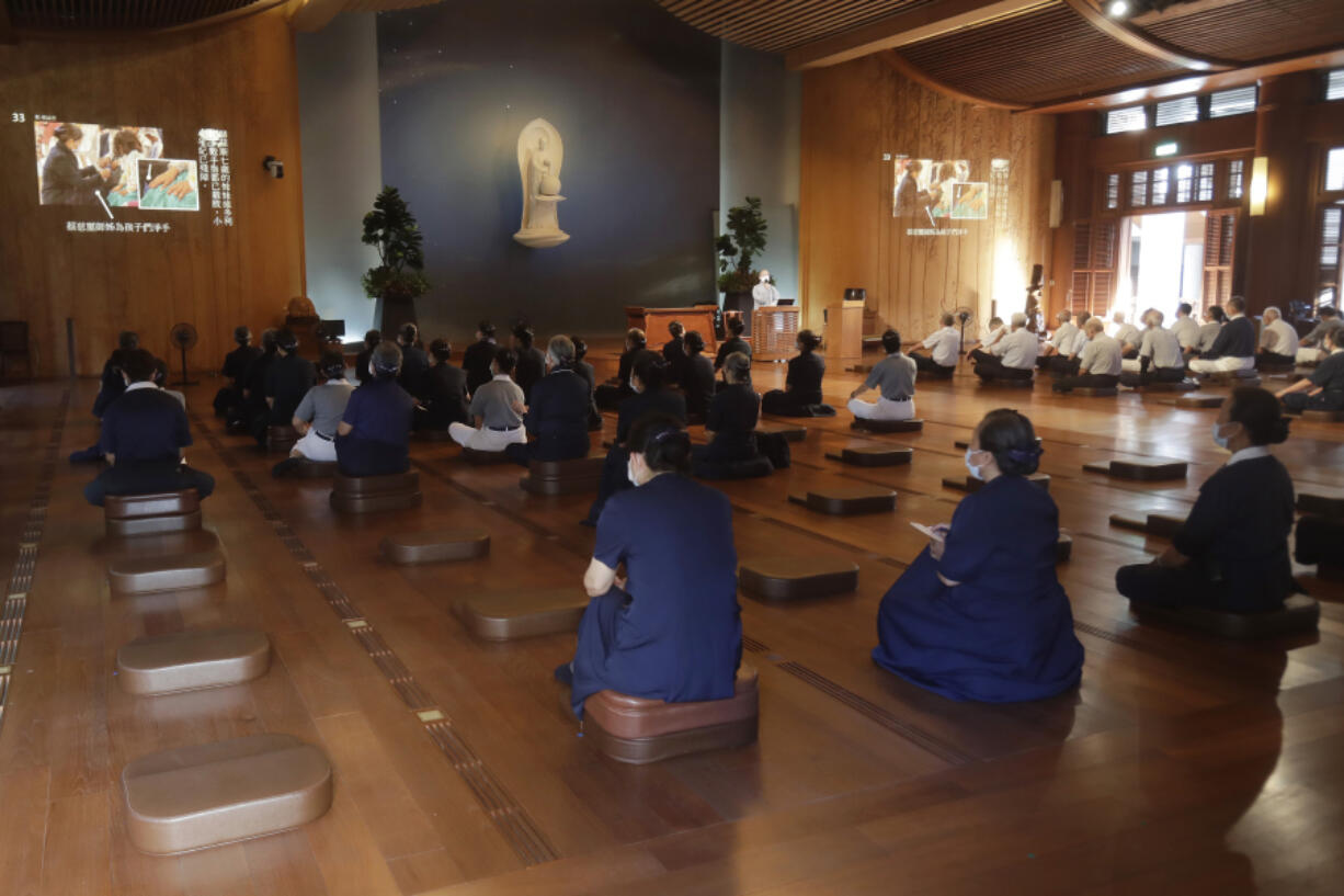 Tzu Chi volunteers listen to Buddhist teachings July 6 before setting out on a volunteer mission in the assembly hall of Jing Si Abode in Hualien, Taiwan.