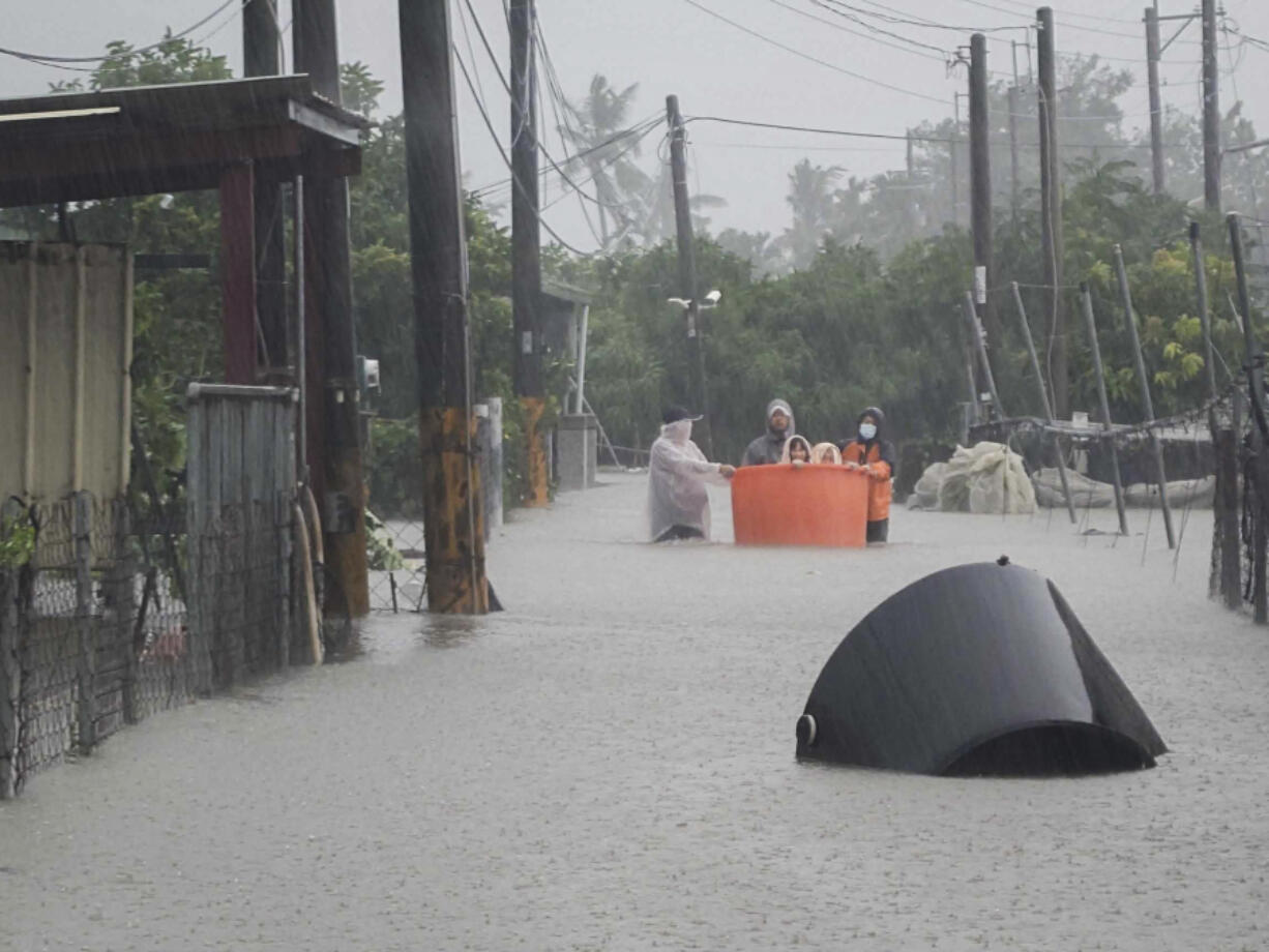 This photo released by Pingtung Fire Department shows, local residents being evacuated during floods after Typhoon Gaemi made landfall in Pintung county, Taiwan, Thursday, July 25, 2024.