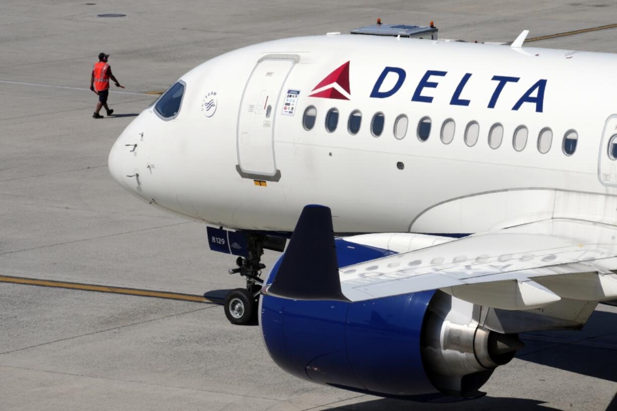 FILE - A Delta Air Lines jet leaves the gate, Friday, July 19, 2024, at Logan International Airport in Boston. Some airline issues are continuing on Monday after a faulty software update caused technological havoc worldwide and resulted in several carriers grounding flights, but the number of flights impacted is declining.