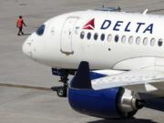 FILE - A Delta Air Lines jet leaves the gate, Friday, July 19, 2024, at Logan International Airport in Boston. Some airline issues are continuing on Monday after a faulty software update caused technological havoc worldwide and resulted in several carriers grounding flights, but the number of flights impacted is declining.