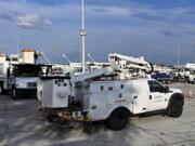 Utility trucks sit parked at a CenterPoint Energy staging center at the Houston Race Track in Houston, Wednesday, July 10, 2024. Millions of residents lost power after Hurricane Beryl made landfall.