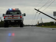 Power lines downed by the effects of Hurricane Beryl block a highway near Palacios, Texas, Monday, July 8, 2024.