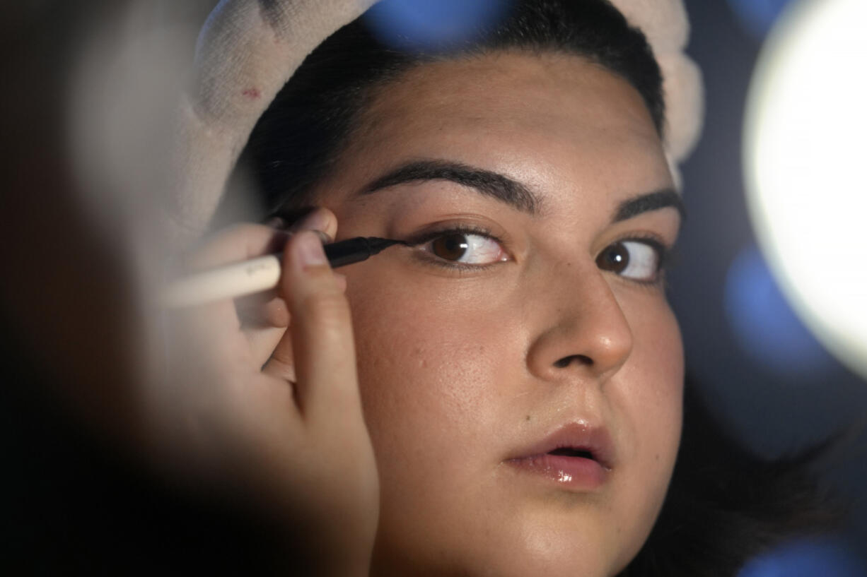 Daniella L&oacute;pez White uses a mirror while applying makeup May 14, 2024, at her apartment in Boston. L&oacute;pez White, who graduated from Emerson College in Boston this month and is on a tight budget, said TikTok influencers have helped her with tips on how to find affordable clothes at places like H&amp;M and thrift shops.