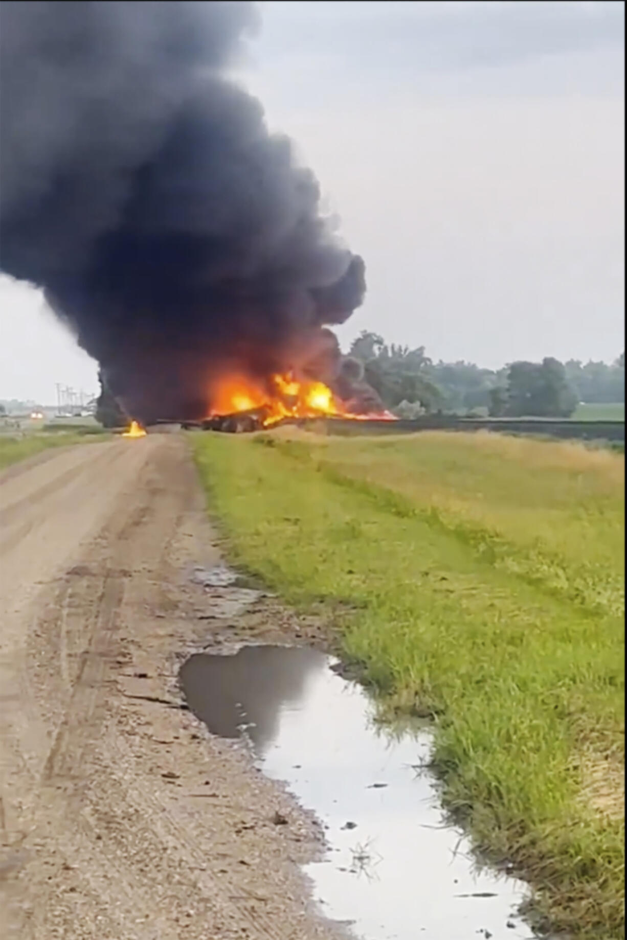 This photo provided by Doug Zink, smoke fills the sky after a train derailment on Friday, July 5, 2024 near Carrington, N.D.   Rail cars containing hazardous material derailed and burst into flames early Friday in a remote area of North Dakota, but emergency officials say no one was hurt and the threat to those living nearby appears to be minimal.