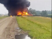 This photo provided by Doug Zink, smoke fills the sky after a train derailment on Friday, July 5, 2024 near Carrington, N.D.   Rail cars containing hazardous material derailed and burst into flames early Friday in a remote area of North Dakota, but emergency officials say no one was hurt and the threat to those living nearby appears to be minimal.