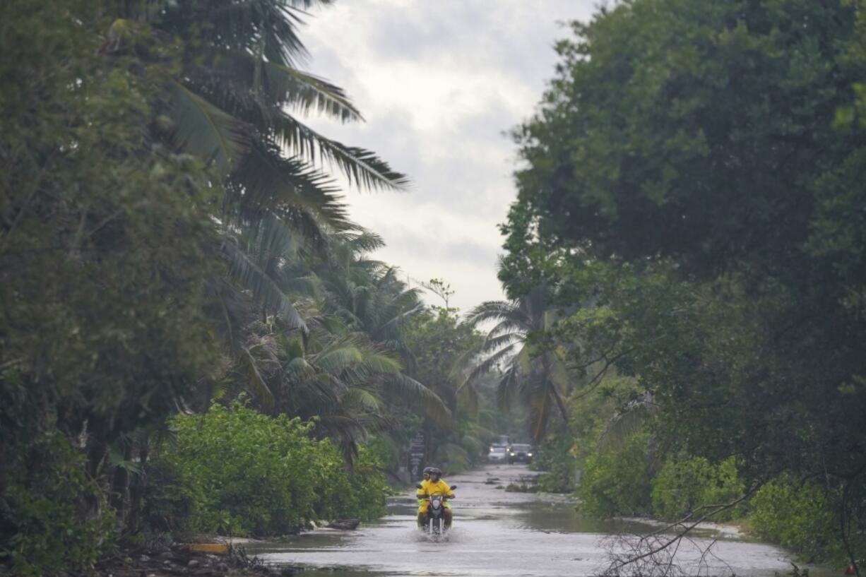 A motorcyclist manuevers a street flooded by heavy rains from Hurricane Beryl, in Tulum, Mexico, July 5, 2024.