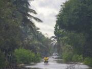 A motorcyclist manuevers a street flooded by heavy rains from Hurricane Beryl, in Tulum, Mexico, July 5, 2024.