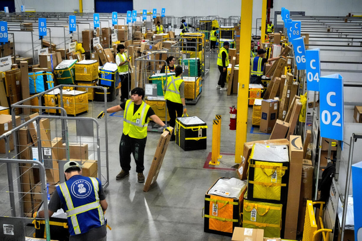 FILE - Amazon employees load packages on carts before being put on to trucks for distribution for Amazon&rsquo;s annual Prime Day event at an Amazon&rsquo;s DAX7 delivery station on Tuesday, July 16, 2024, in South Gate, Calif.