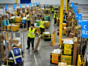 FILE - Amazon employees load packages on carts before being put on to trucks for distribution for Amazon&rsquo;s annual Prime Day event at an Amazon&rsquo;s DAX7 delivery station on Tuesday, July 16, 2024, in South Gate, Calif.