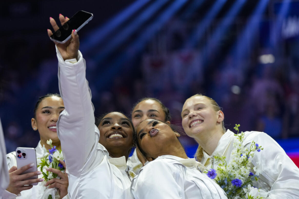 Simone Biles takes a selfie with Suni Lee, left, Hezly Rivera (blocked), Jordan Chiles and Jade Carey, right, at the United States Gymnastics Olympic Trials on Sunday, June 30, 2024, in Minneapolis.