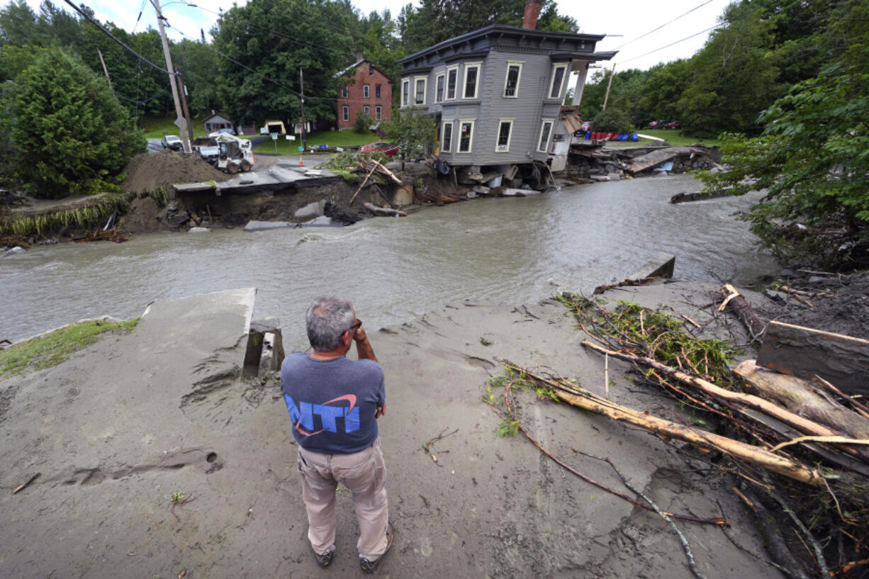 FILE - Rick Gordon, of Plainfield, Vt., looks at what remains of Mill Street and an apartment building after remnants of Hurricane Beryl caused flooding and destruction, Friday, July 12, 2024, in Plainfield. On Wednesday, July 24, Vermont opened the first of four flood recovery centers while officials waited to find out whether the state qualifies for federal help through a disaster declaration.