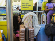 People wait in line at Chicago O&#039;Hare International Airport after a software glitch caused widespread outages, flight delays and cancelations as reported by airlines around the world, Friday, July 19, 2024, in Chicago.