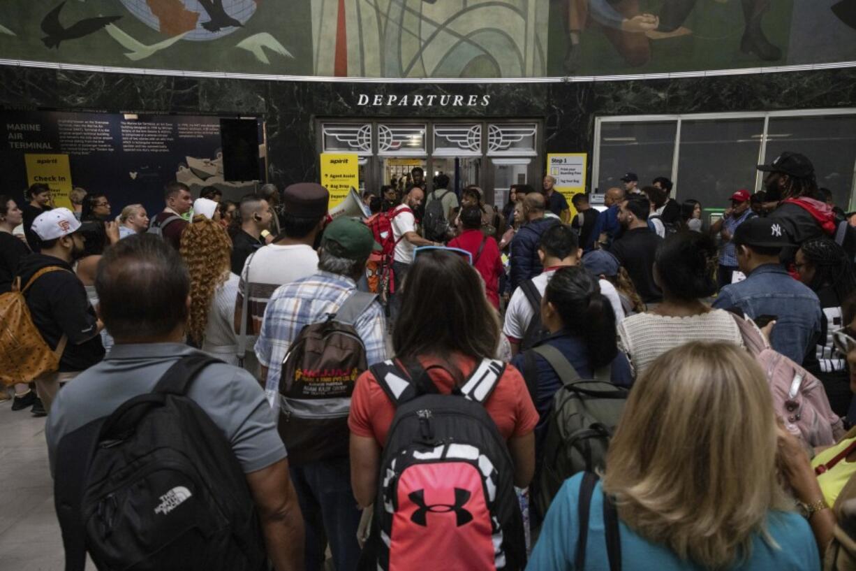 Customers wait in line at a departure area for Spirit Airlines at LaGuardia Airport in New York on Friday, July 19, 2024, after a faulty CrowdStrike update caused a major internet outage for computers running Microsoft Windows.