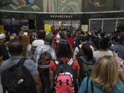 Customers wait in line at a departure area for Spirit Airlines at LaGuardia Airport in New York on Friday, July 19, 2024, after a faulty CrowdStrike update caused a major internet outage for computers running Microsoft Windows.