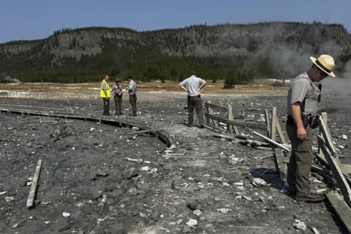 In this photo released by the National Park Service, park staff assess the damage to Biscuit Basin boardwalks after a hydrothermal explosion at Biscuit Basin in Yellowstone National Park, Wyo., Tuesday, July 23, 2024.