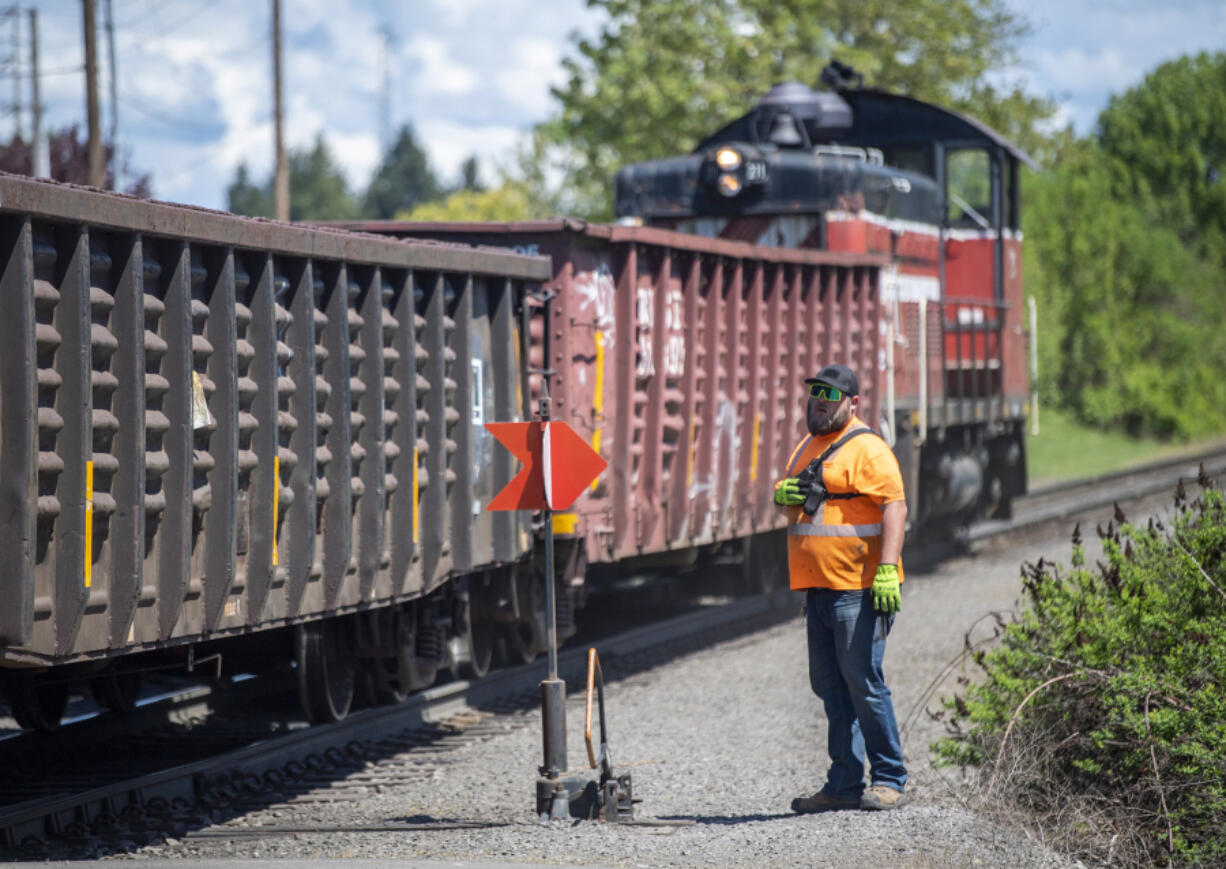 Portland Vancouver Junction Railroad conductor Brad Johnston watches as a train moves down the tracks near St. Johns Road in May 2023. The Clark County Council recently decided not to move forward with hiring a consultant to complete regulations for the section of rail line set aside for industrial development. The question of where the county goes from here remains unanswered.