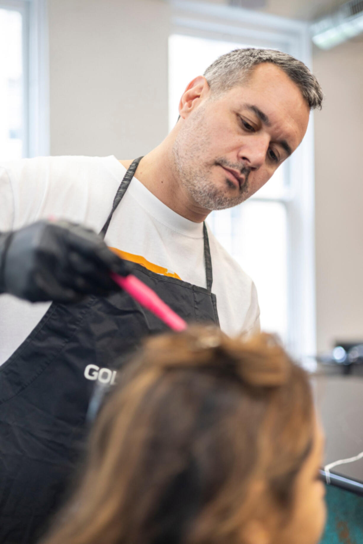 Alexey Kats, 41, works on the hair of Michelle Gillen-Doobrajh, 41, of Haddonfield, N.J., at Center City&rsquo;s Architeqt Color Bar in Philadelphia, Pa.