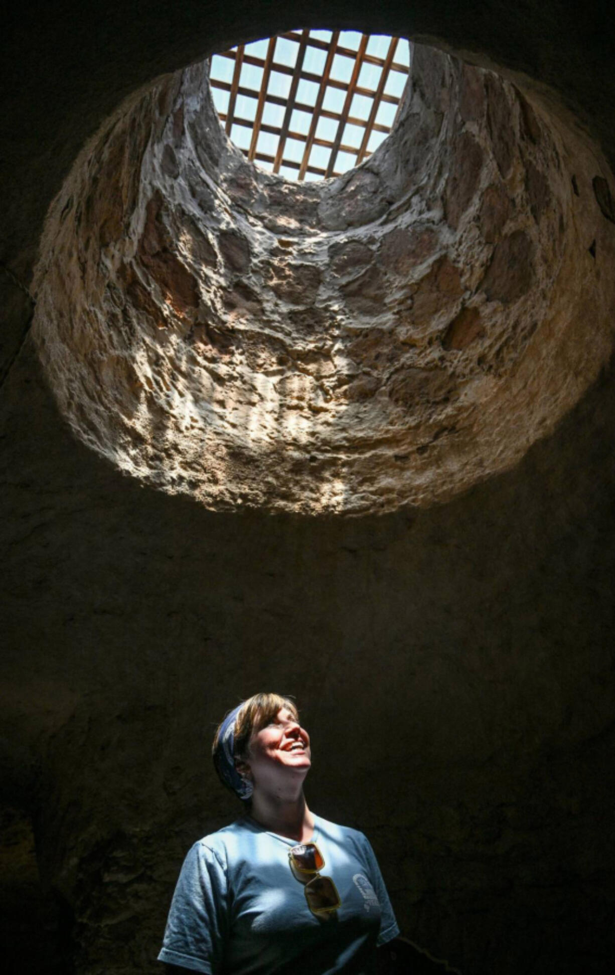 Shera Franzman, director of operations at the Forestiere Underground Gardens in Fresno, Calif., keeps cool below ground July 22 while looking up into one of the gardens&rsquo; many skylight openings.