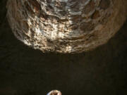 Shera Franzman, director of operations at the Forestiere Underground Gardens in Fresno, Calif., keeps cool below ground July 22 while looking up into one of the gardens&rsquo; many skylight openings.