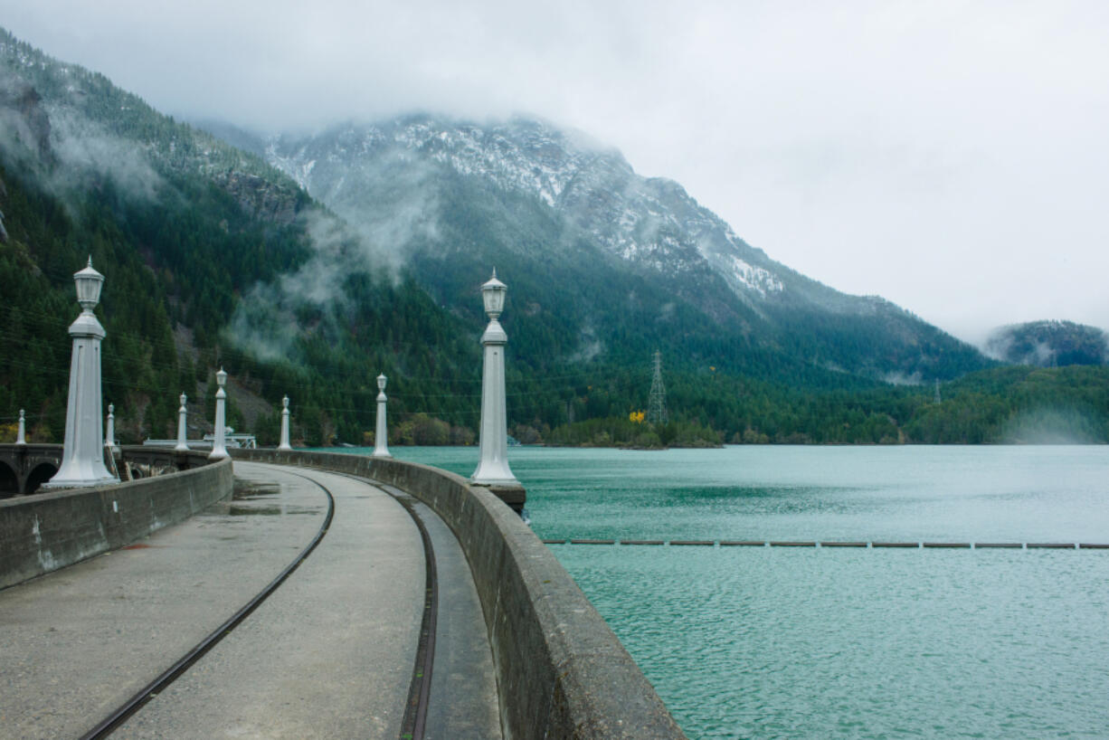 A one lane crosses a clear water dam in North Cascades National Park, east of Mount Baker.