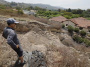 Homeowner Mike Hong views a large fissure that has continued to grow since February damaging a neighbor&Ccedil;&fnof;&Ugrave;s Portuguese Bend home. The landslide damage in the area has accelerated following two winters of heavy rain in Rancho Palos Verdes. (Allen J.